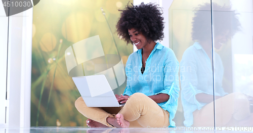 Image of black women using laptop computer on the floor