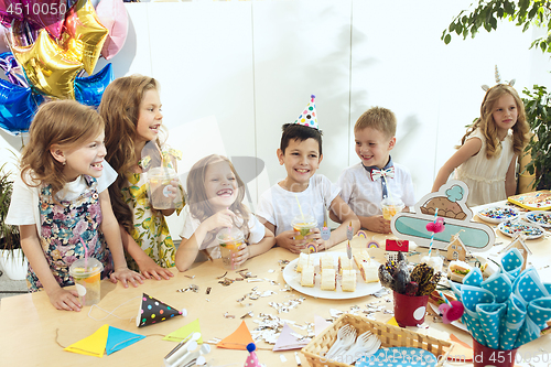 Image of Girl birthday decorations. table setting with cakes, drinks and party gadgets.