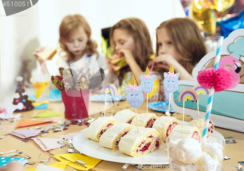 Image of Girl birthday decorations. table setting with cakes, drinks and party gadgets.