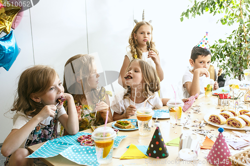 Image of Girl birthday decorations. table setting with cakes, drinks and party gadgets.