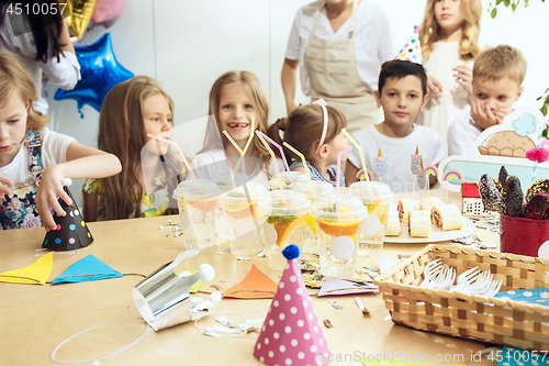 Image of Girl birthday decorations. table setting with cakes, drinks and party gadgets.