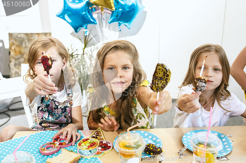 Image of Girl birthday decorations. table setting with cakes, drinks and party gadgets.