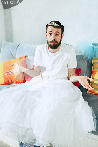 Image of Man in ballet tutu on white at home