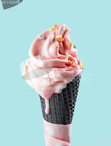 Image of pink melting ice cream in black waffle cone
