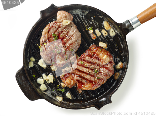 Image of pan of grilled steaks on white background