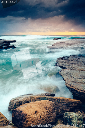 Image of Storm clouds and moody oceans as mosrning breaks on the horizon