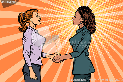 Image of African and Caucasian businesswomen shaking hands