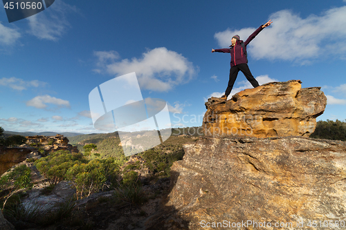 Image of Female hiker on top of a pagodas after climbing up with views