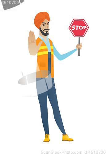 Image of Young hindu builder holding stop road sign.