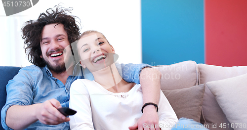 Image of Young couple on the sofa watching television