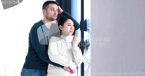 Image of multiethnic couple relaxing at modern home indoors