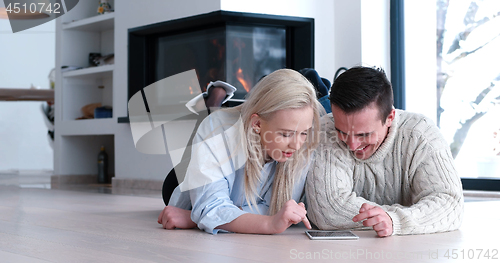 Image of Young Couple using digital tablet on the floor