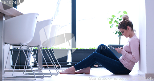 Image of young women using tablet computer on the floor