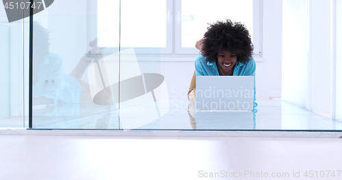 Image of black women using laptop computer on the floor
