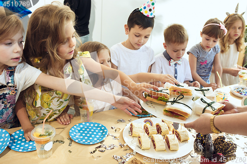 Image of Girl birthday decorations. table setting with cakes, drinks and party gadgets.