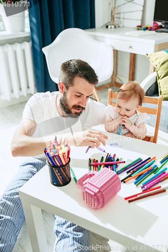 Image of father and his baby daughter at home