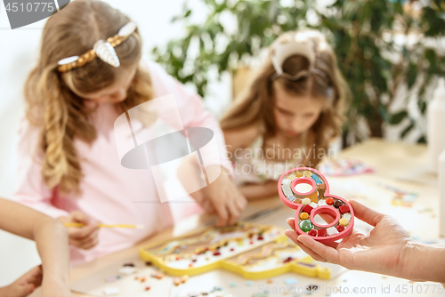 Image of mosaic puzzle art for kids, children\'s creative game. two girls are playing mosaic