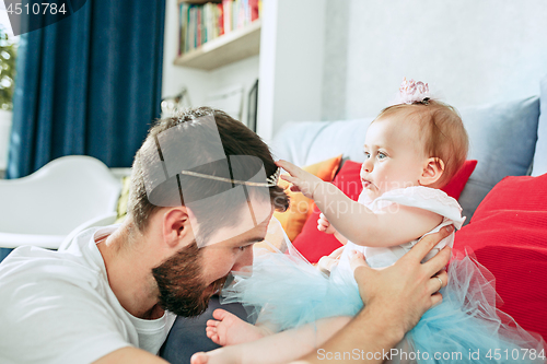 Image of Proud father holding his baby daughter at home