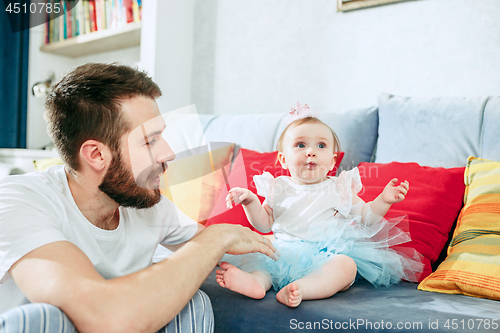 Image of Proud father holding his baby daughter at home
