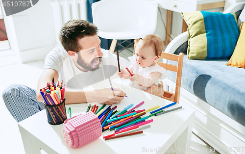 Image of father and his baby daughter at home