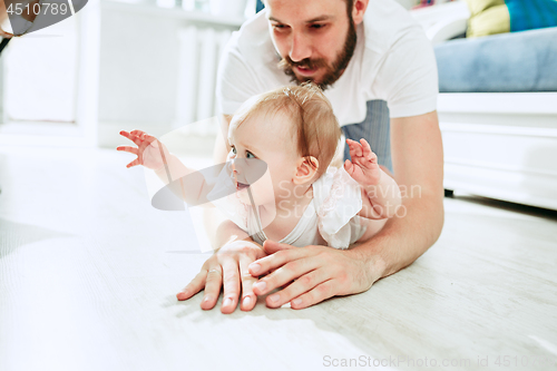 Image of father and his baby daughter at home