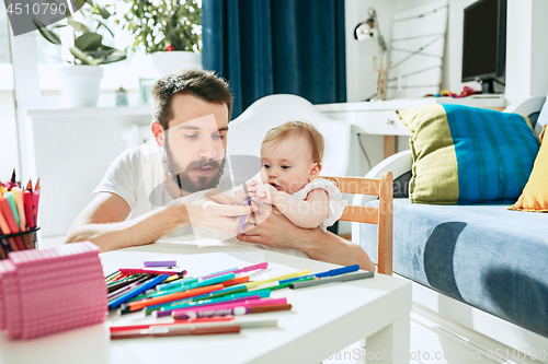 Image of father and his baby daughter at home