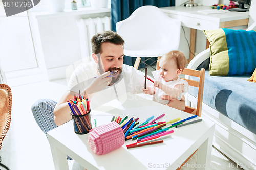 Image of father and his baby daughter at home