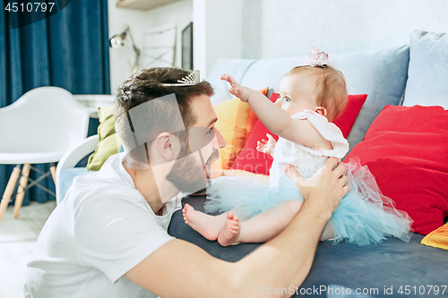 Image of Proud father holding his baby daughter at home