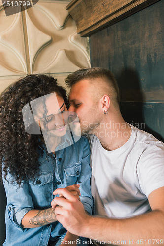 Image of Happy young couple is drinking coffee and smiling while sitting at the cafe