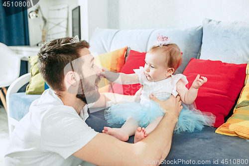 Image of Proud father holding his baby daughter at home