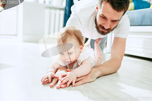 Image of father and his baby daughter at home