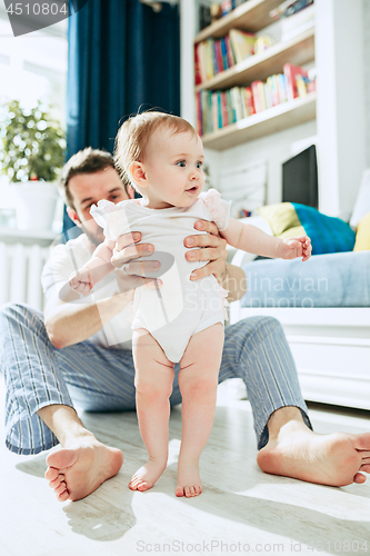 Image of father and his baby daughter at home