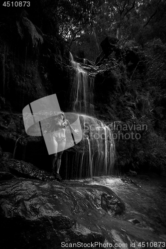 Image of Bikini woman stands in remote bushland waterfall