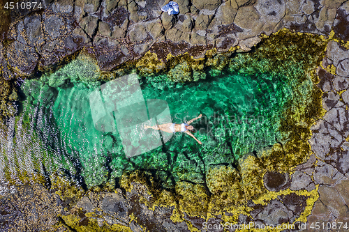 Image of Carefree woman in bikini floating in beautiful rock pool summer 