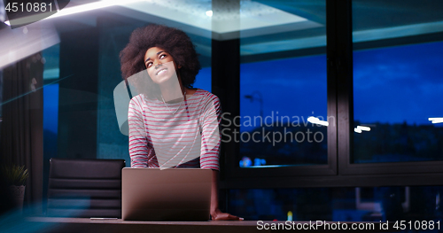 Image of black businesswoman using a laptop in night startup office