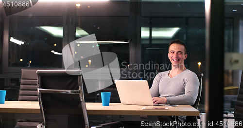 Image of man working on laptop in dark office