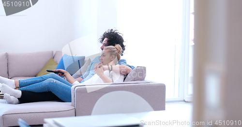 Image of Young couple on the sofa watching television