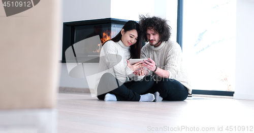 Image of Young Couple using digital tablet on the floor