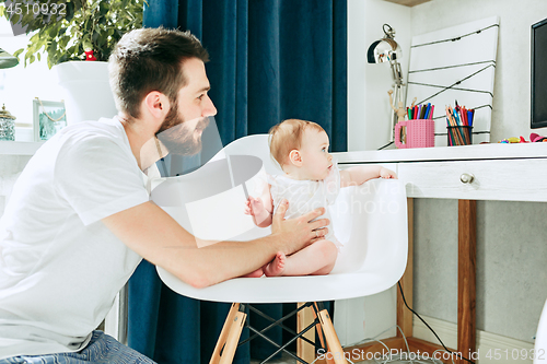 Image of father and his baby daughter at home