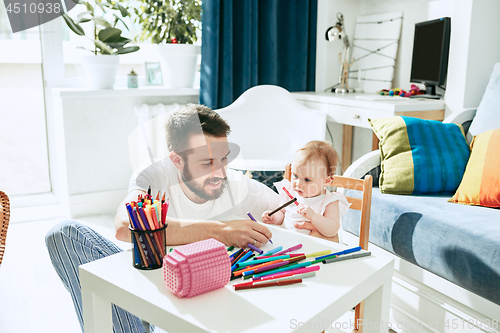 Image of father and his baby daughter at home