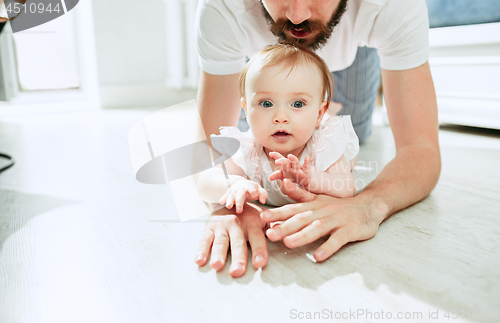 Image of father and his baby daughter at home