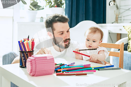 Image of father and his baby daughter at home