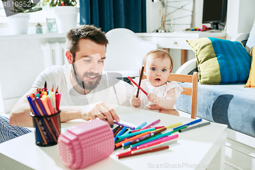 Image of father and his baby daughter at home