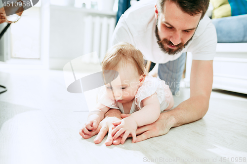 Image of father and his baby daughter at home