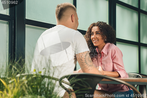 Image of Close up on a man and a woman holding hands at a wooden table