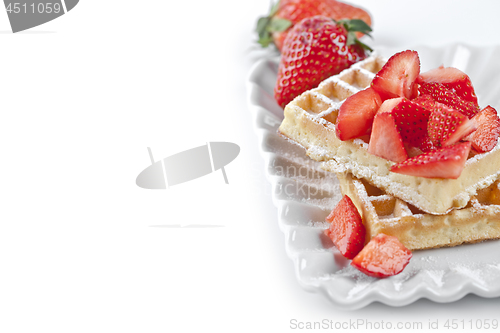 Image of Belgium waffers with sugar powder and strawberries on ceramic pl