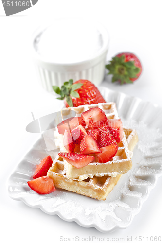 Image of Belgium waffers with sugar powder and strawberries on ceramic pl