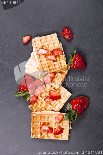 Image of Belgium waffers with strawberries on black board background.