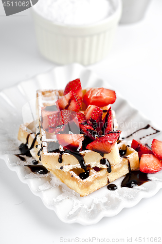 Image of Belgium waffers with sugar powder, strawberries and chocolate on