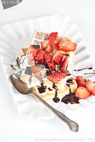 Image of Belgium waffers with sugar powder, strawberries and chocolate on